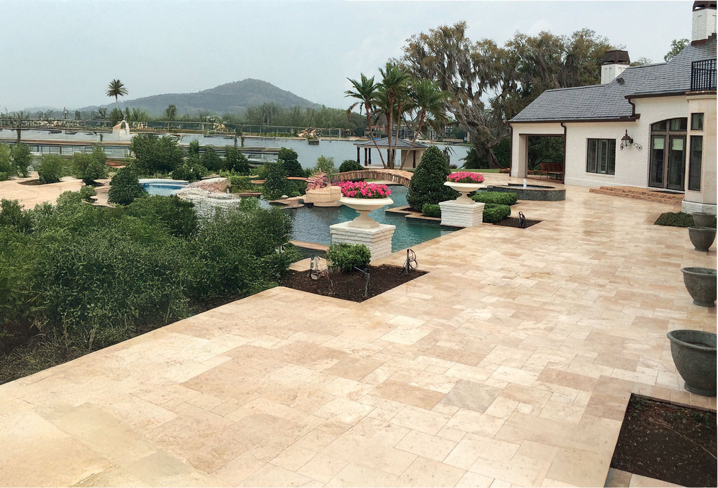Patio area with a pool and scenic view of mountains and water. Aspendos Tumbled Travertine Pavers