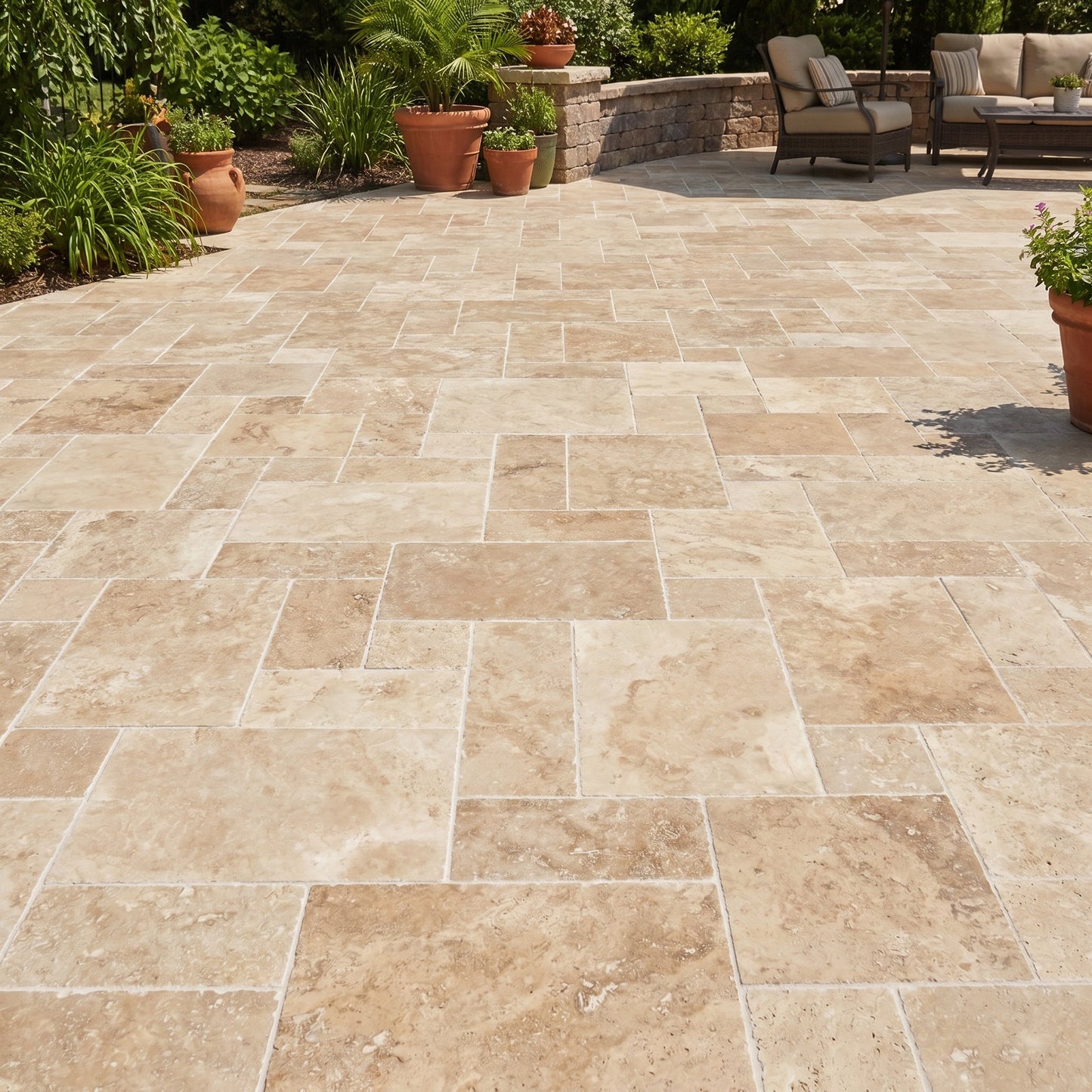 Paved patio with stone tiles, outdoor furniture, and plants in a garden setting.
