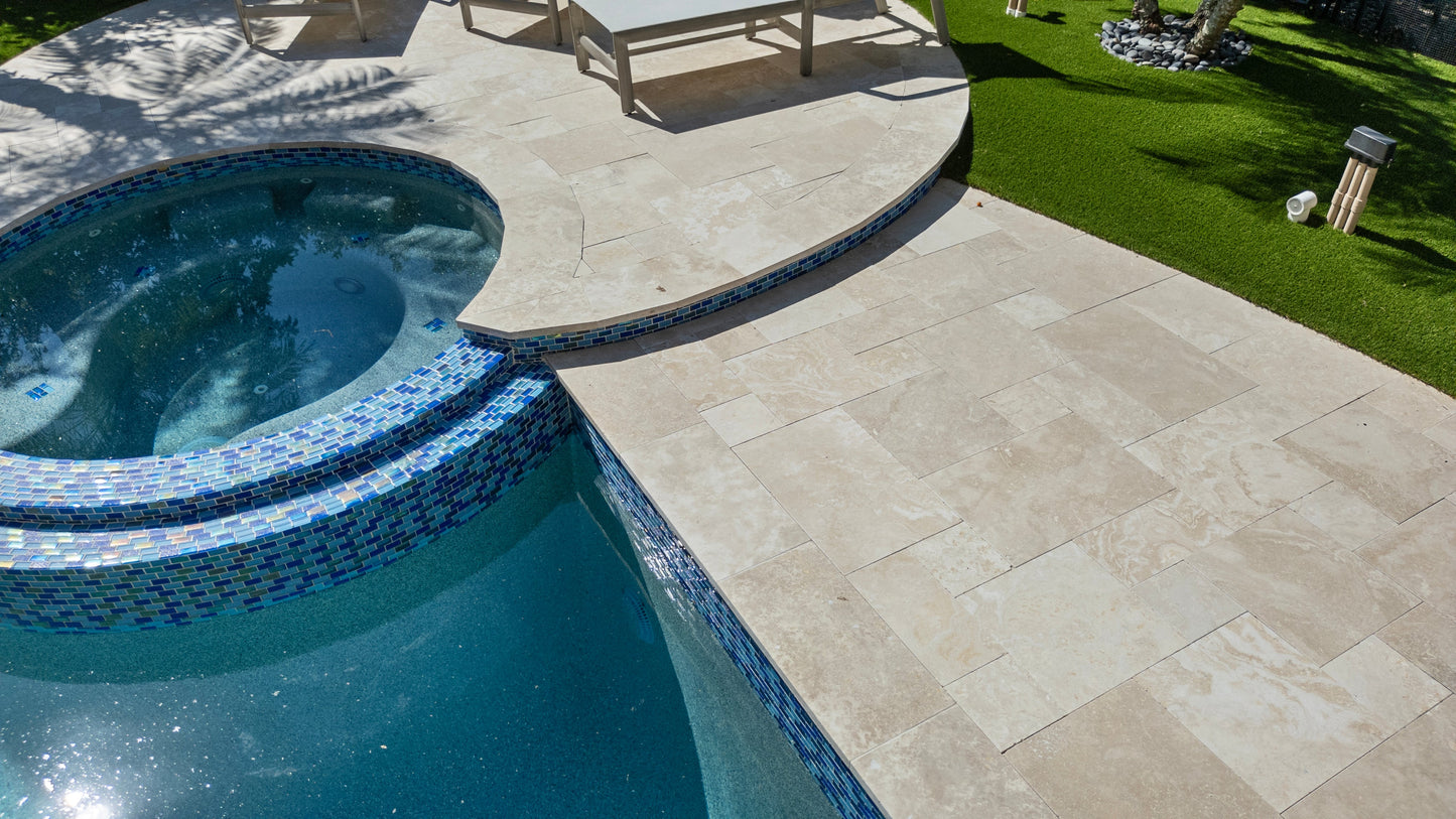 Pool area with tiled pool and stone patio