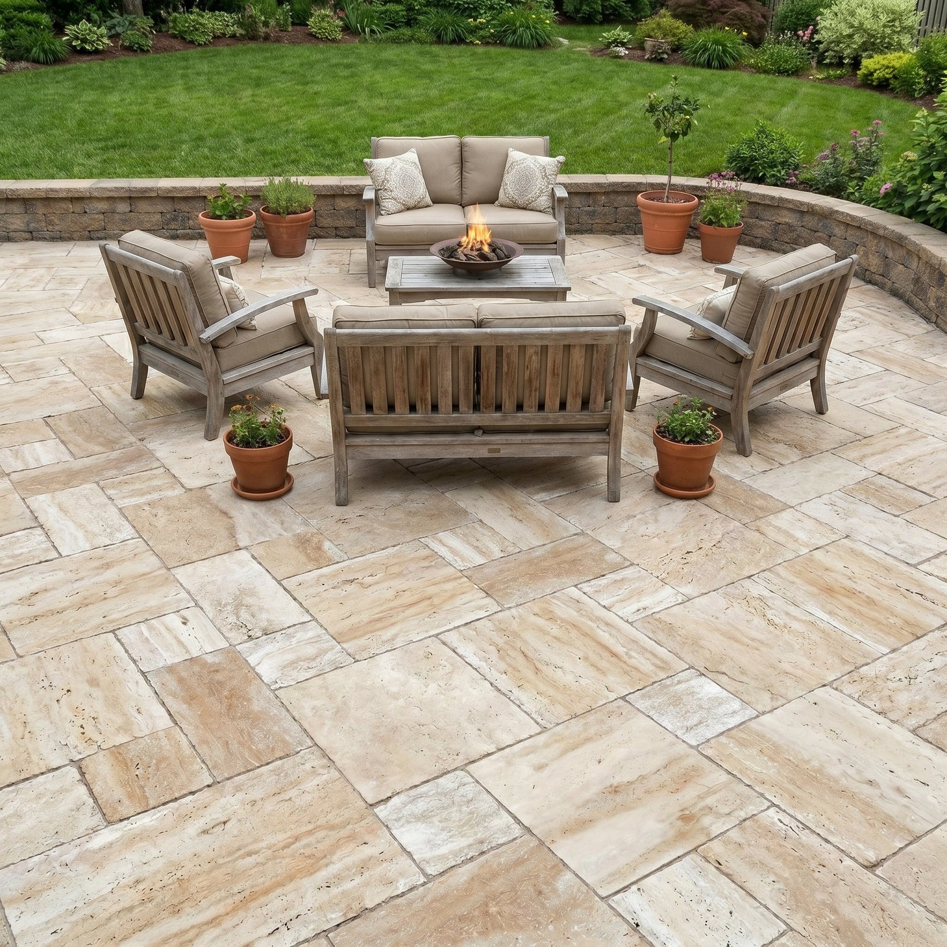 Outdoor patio with stone pavement, wooden furniture, and potted plants. Patara Beige Vein-cut Tumbled Travertine Pavers