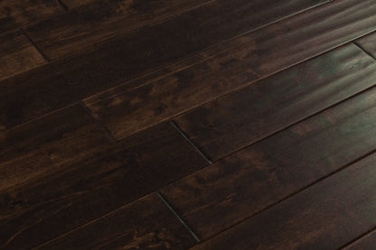 Close-up of Maple Distressed/Handscraped Solid Hardwood Flooring Planks, 3/4 x 5 inches, in a rich Walnut finish, showcasing its natural texture and warmth.