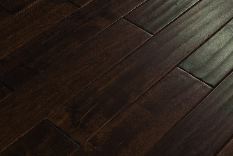 Close-up of Maple Distressed/Handscraped Solid Hardwood Flooring Planks, 3/4 x 5 inches, in a rich Walnut finish, showcasing its natural texture and warmth.