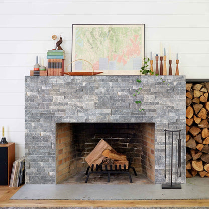 Gray stone fireplace with wooden logs, decorative items, and a map above it. Bluestone Marble 3D Ledger Stone Panel 6"x24"