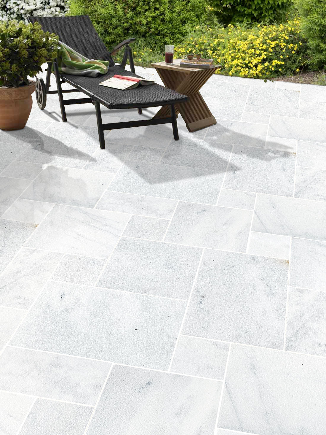 Outdoor patio with white tiles, lounge chair, and small table. Turkish Carrara White Marble Sand-Blasted Pavers