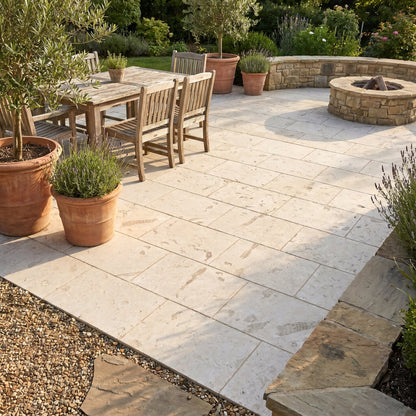 Outdoor patio with wooden furniture, potted plants, and a fire pit. Shell Stone White Tumbled Limestone Pavers