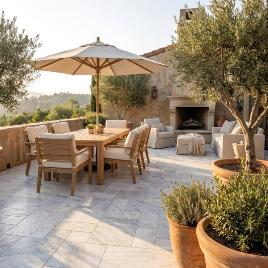 Outdoor patio with wooden furniture, umbrella, and fireplace. Solto White Marble Leathered Pavers